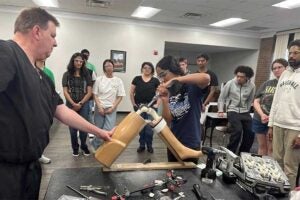Students look on as a student participates in a knee replacement demonstration put on by MAPS