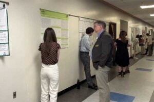 Dean Wes Stites listens to a student explaining their research at the 2026 COS Research Day