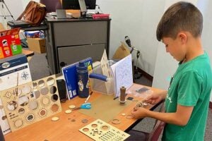 A young student builds a connection with science building a device during a Summer Day Camp activity