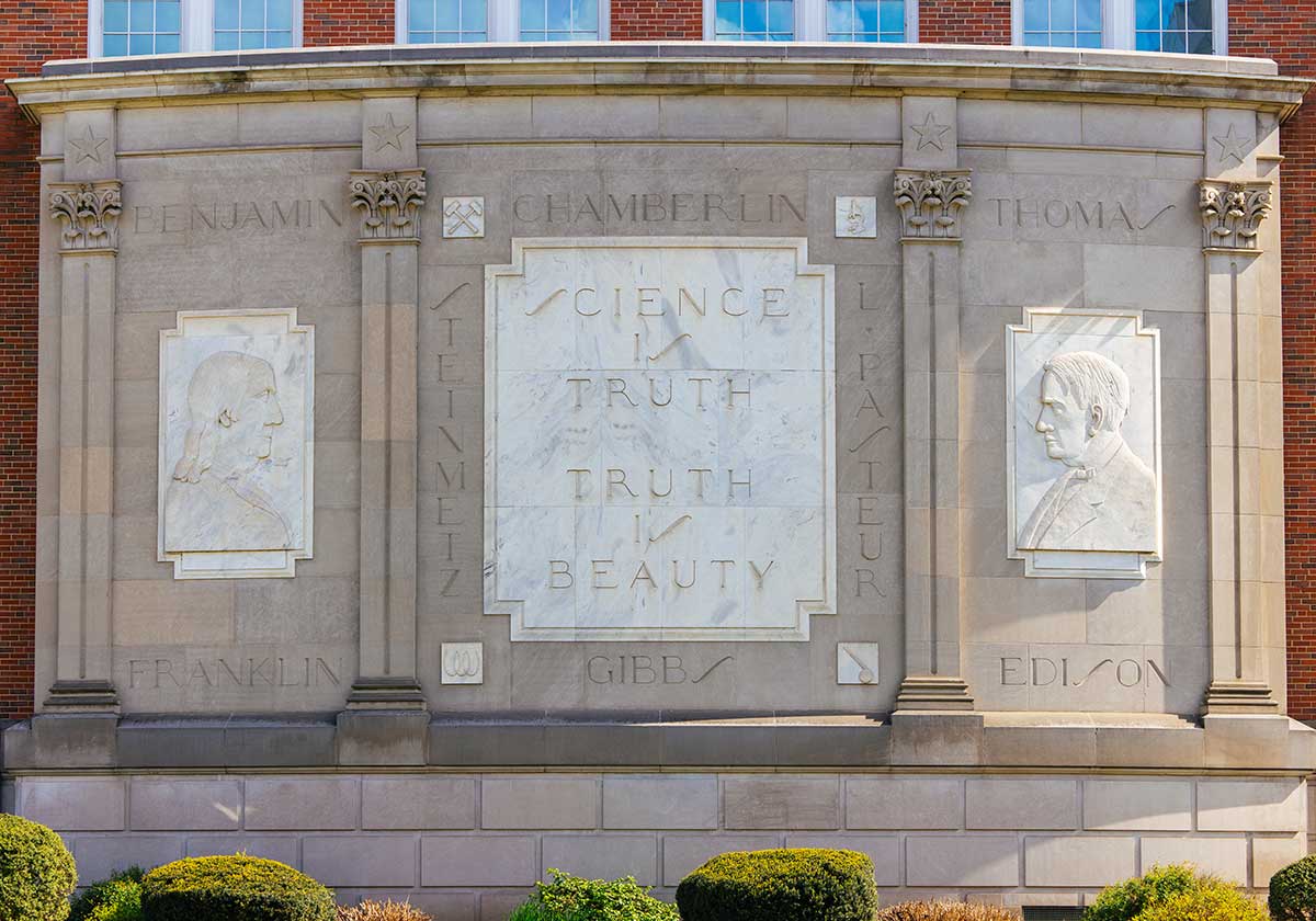 Three-story stone bas-relief on north face of Marshall's Science Building featuring portraits of Benjamin Franklin and Thomas Jefferson flanking the names of Chamberlin, L. Pasteur, Gibbs, and Steinmetz and the phrase "Science is Truth, Truth is Beauty"