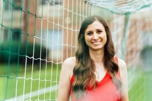 Mathematics alum Skye Reymond stands in front of a soccer net, reflecting her role with US Soccer