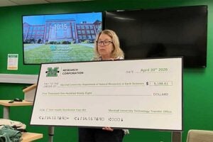 Chair Dr. Mindy Armstead presents a check representing patent royalties from a DNA process developed by former students of Dr. Liz Murray