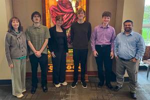Group of Marshall University physics students and faculty standing in front of a stained-glass window at the Appalachian Section of the American Association of Physics Teachers Fall 2026 Meeting at Ohio University. The group participated in presentations on physics research, physics education, accessibility, and student support initiatives.