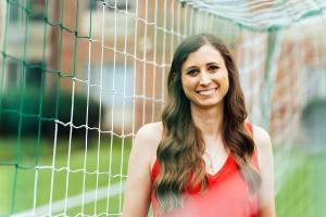 Mathematics alum Skye Reymond stands in front of a soccer net, reflecting her role with US Soccer