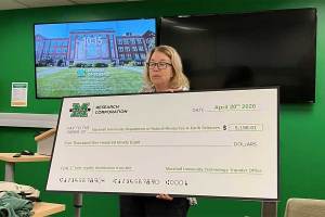 Chair Dr. Mindy Armstead presents a check representing patent royalties from a DNA process developed by former students of Dr. Liz Murray