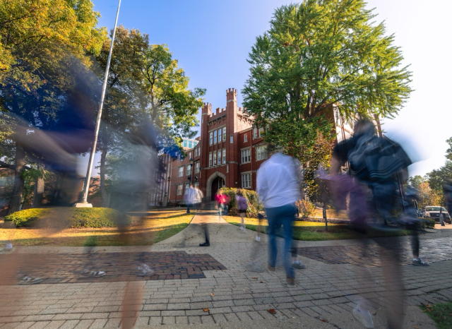 photo of Old Main with people walking by