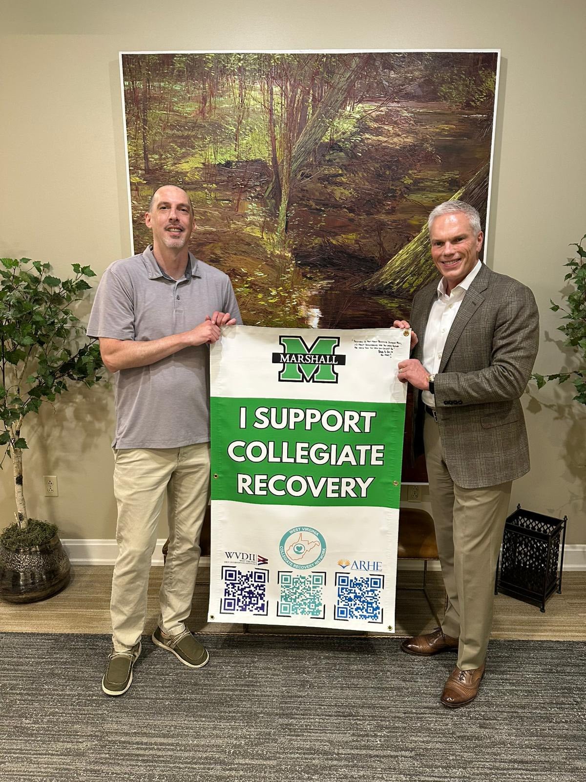 Photo of two individuals with I Support Collegiate Recovery banner