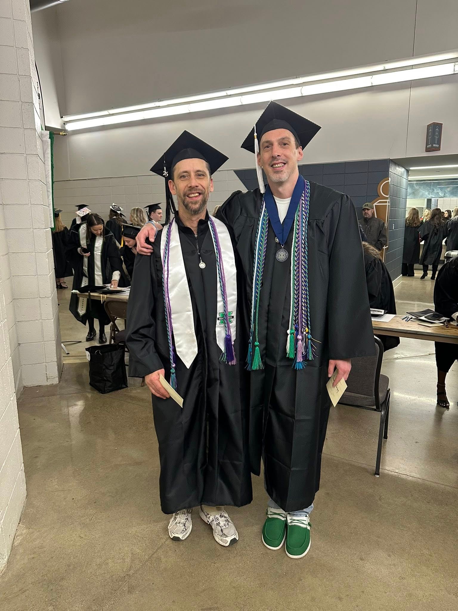 Photo of two individuals in commencement cap and gown