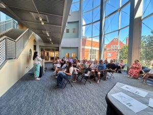 girl reading her story at a podium to an audience in a library