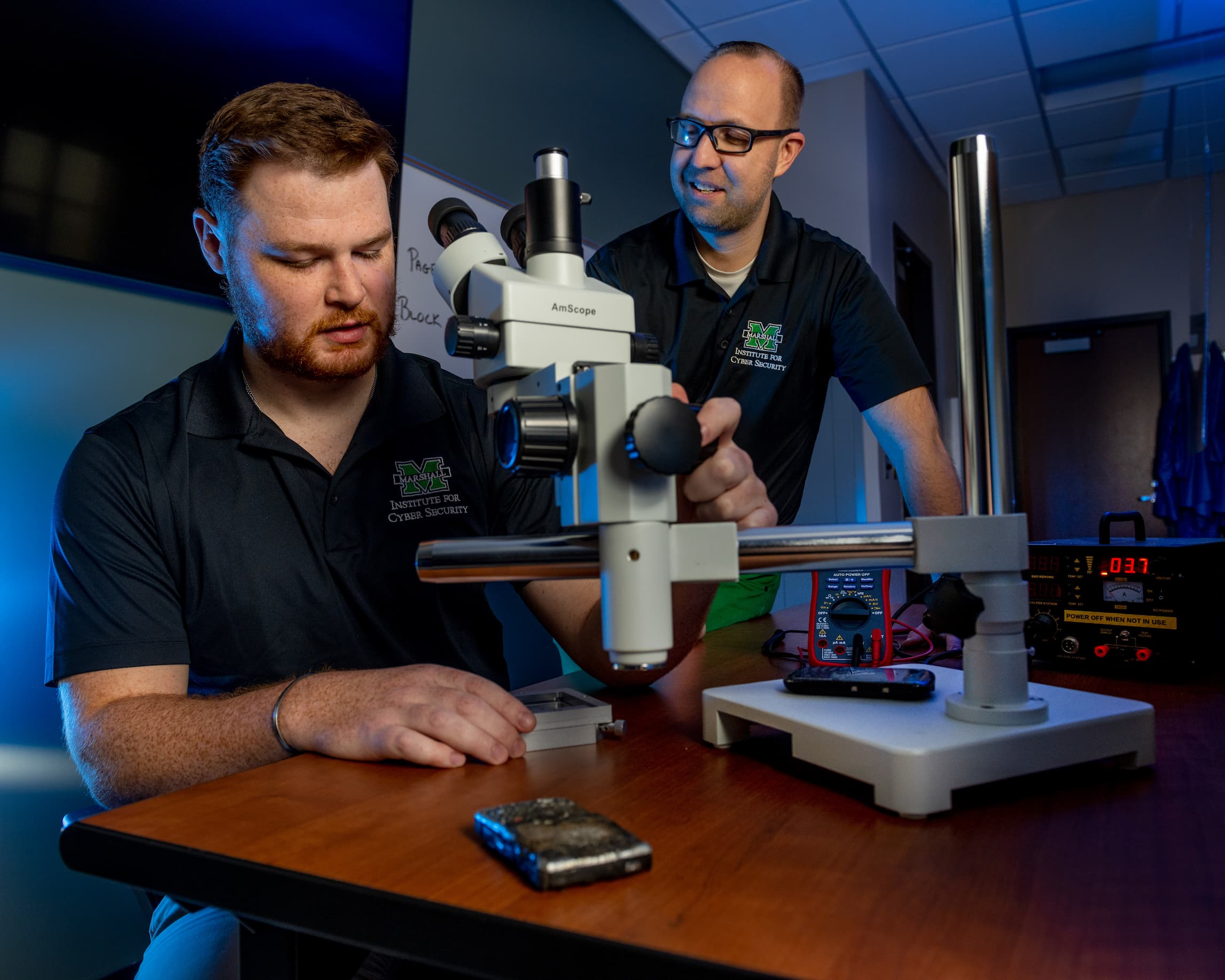 ICS staff work on cyber research using a microscope
