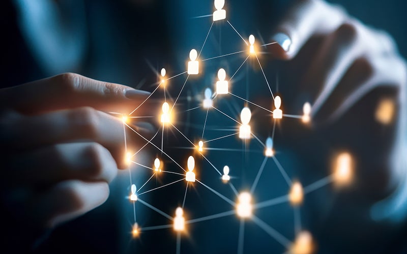 Hands expand a digital graphic on clear glass