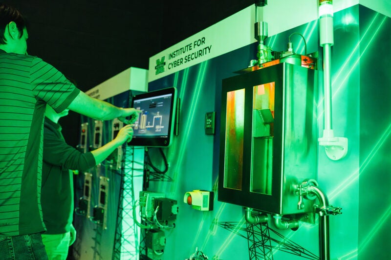 Two people work on a touch screen in the Cyber Hive at Marshall University's Institute for Cyber Security