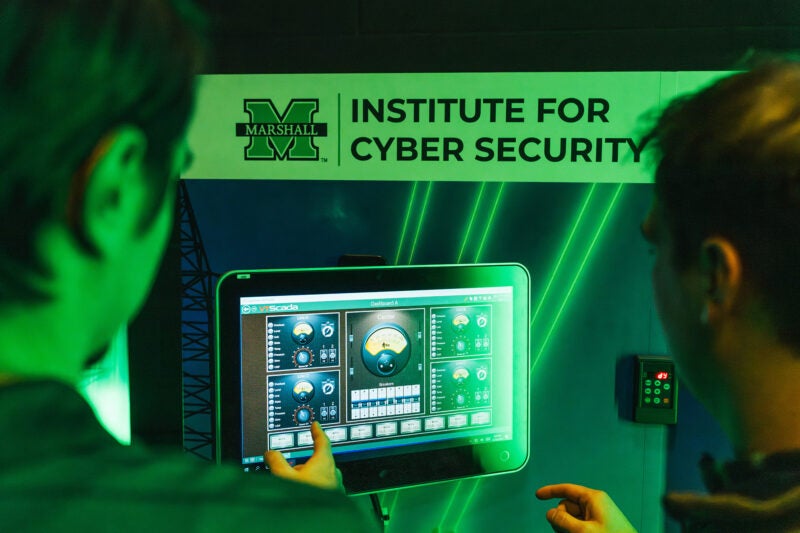 Two people work on a touch screen in the Cyber Hive at Marshall University's Institute for Cyber Security