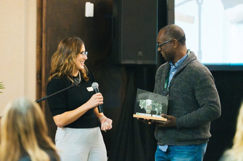 A man is presented an award during a conference