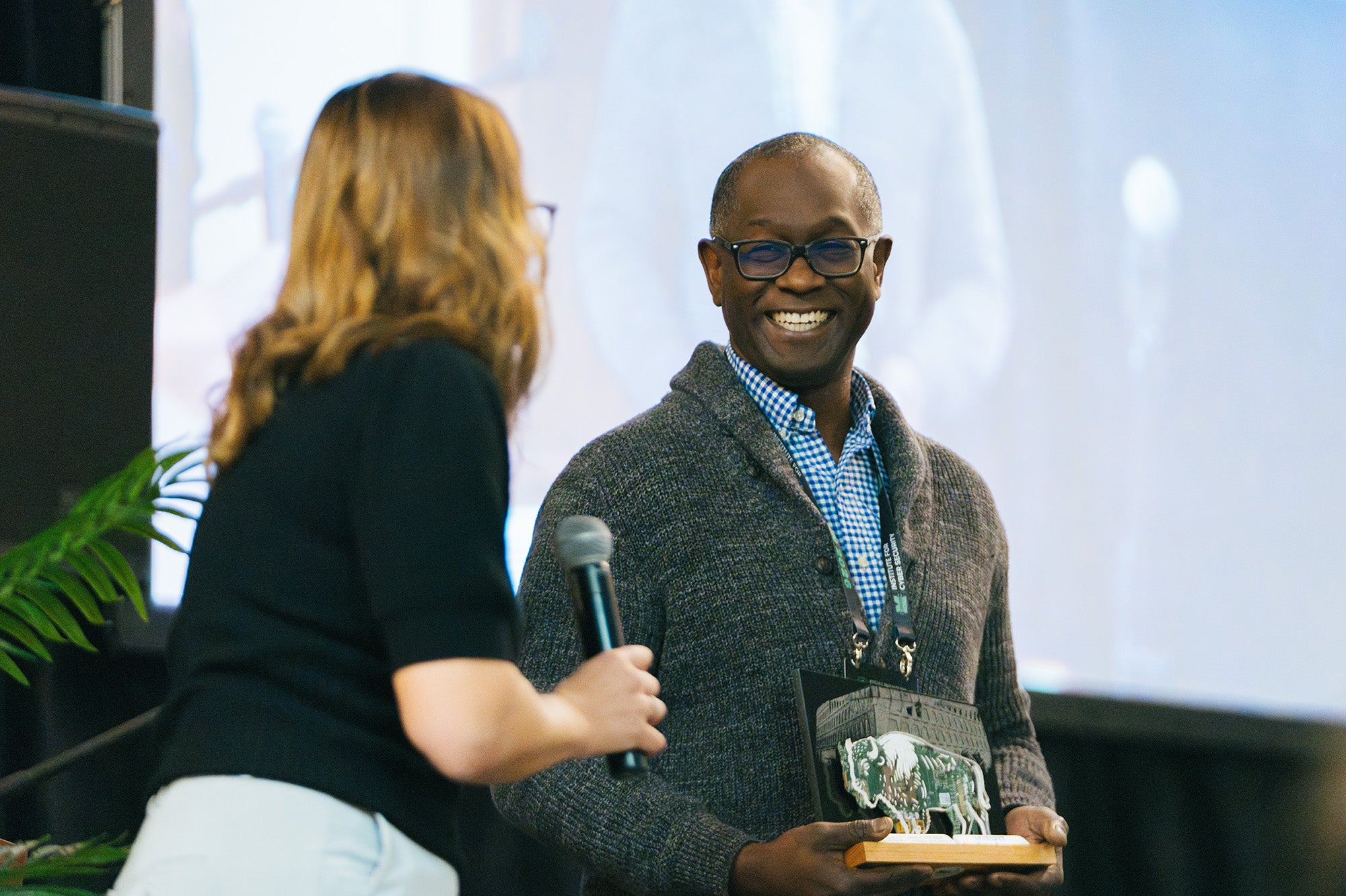 A man is presented an award during a conference