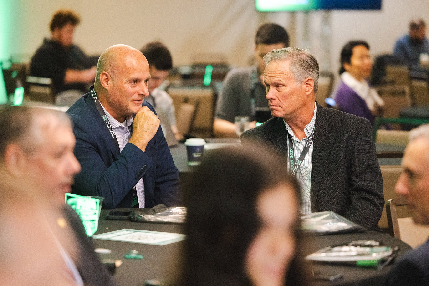 Attendees chat at a table during a CyberCon session