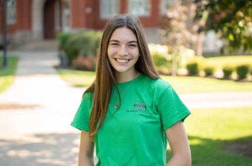 Image of female student on campus in front of Old Main