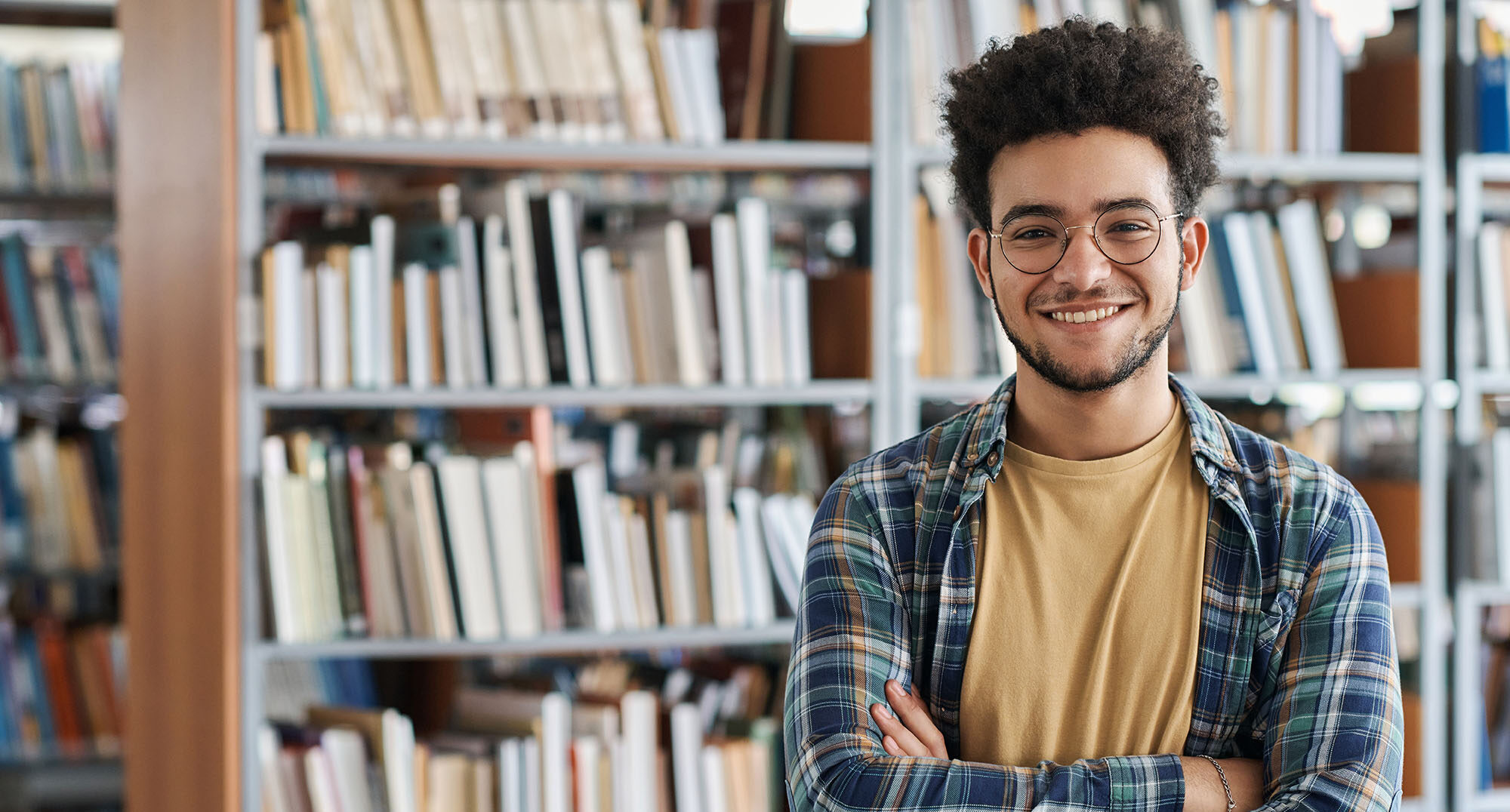 Image of student standing in front of book shelf