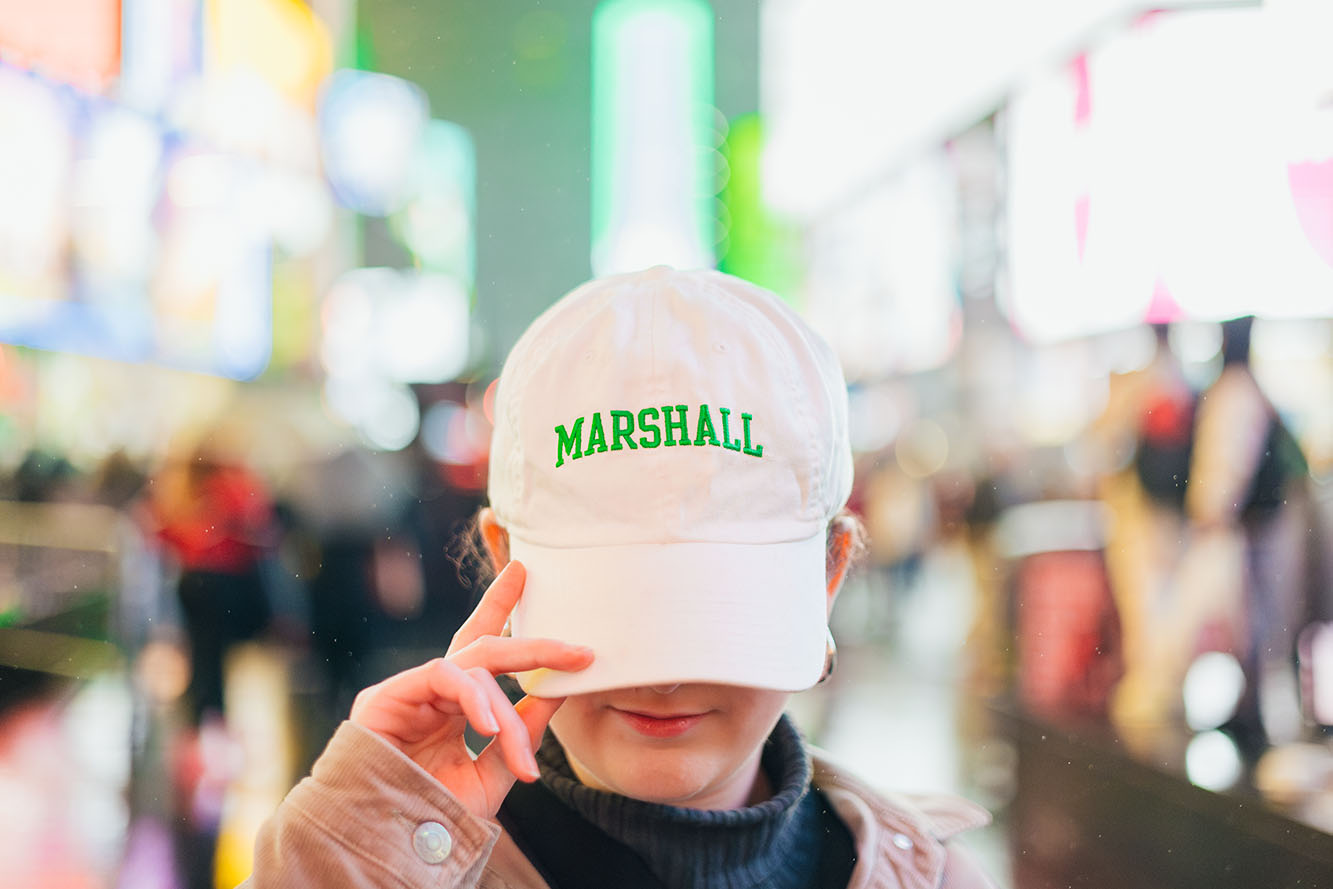 Image of student with Marshall hat in big city