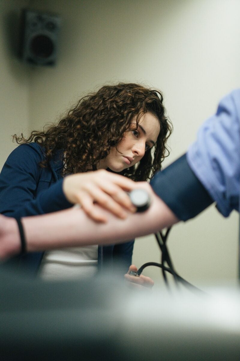 student getting their blood pressure taken by a professor