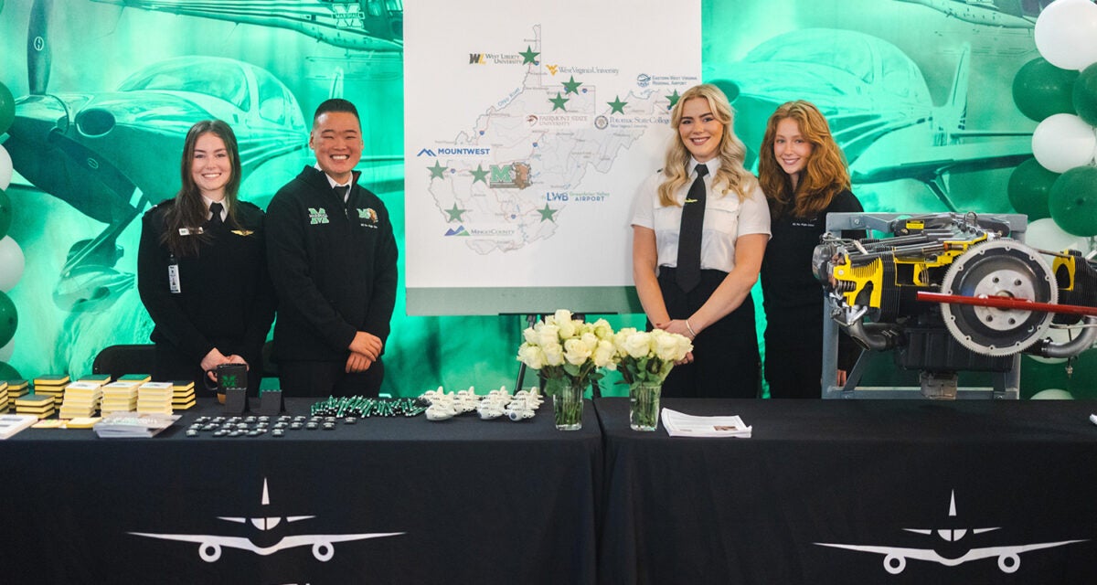 Marshall University Aviation students smile at their table setup during Marshall Day at the Capitol