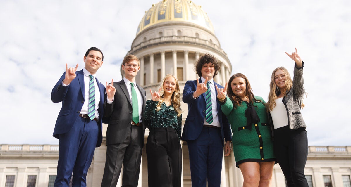 Marshall students smile together in front of the WV State Capitol building