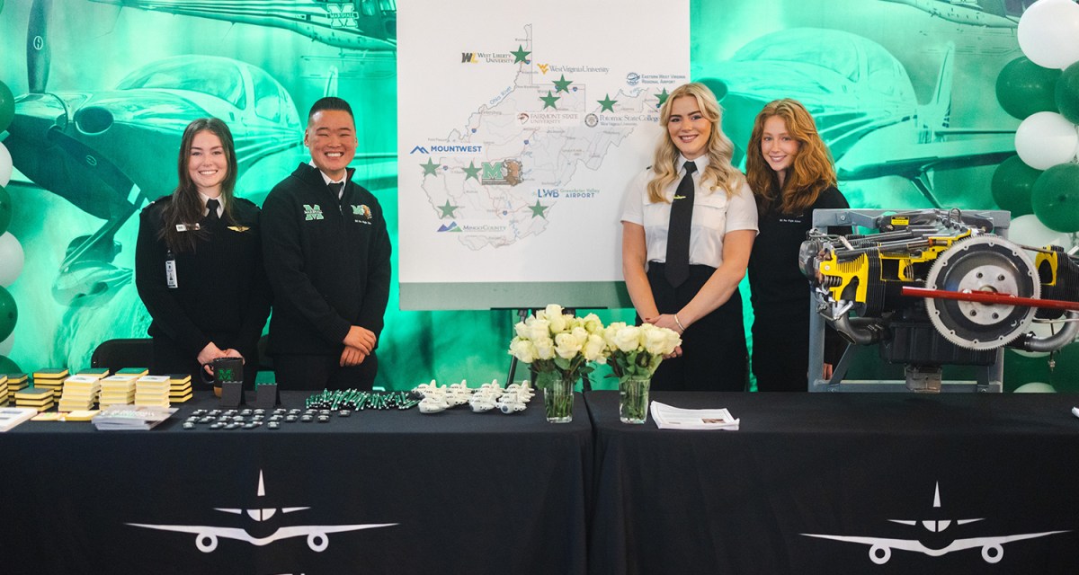 Marshall University Aviation students smile at their table setup during Marshall Day at the Capitol
