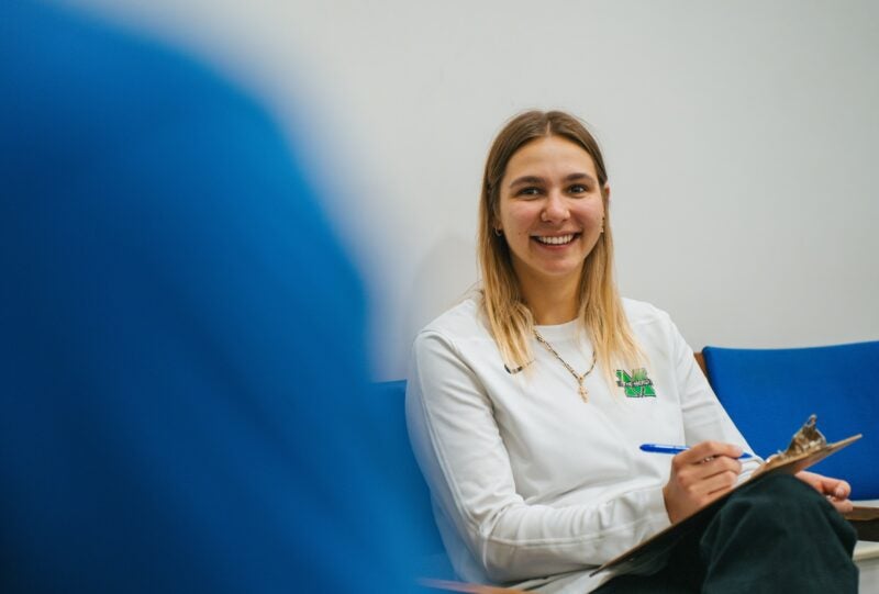 student in a lab doing an evaluation with a clipboard