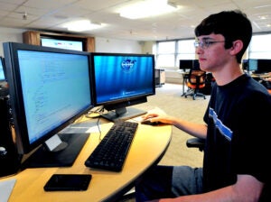 Male student working at a desktop computer