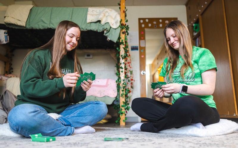 Student play cars in front of their bunk beds in a residence hall at Marshall University
