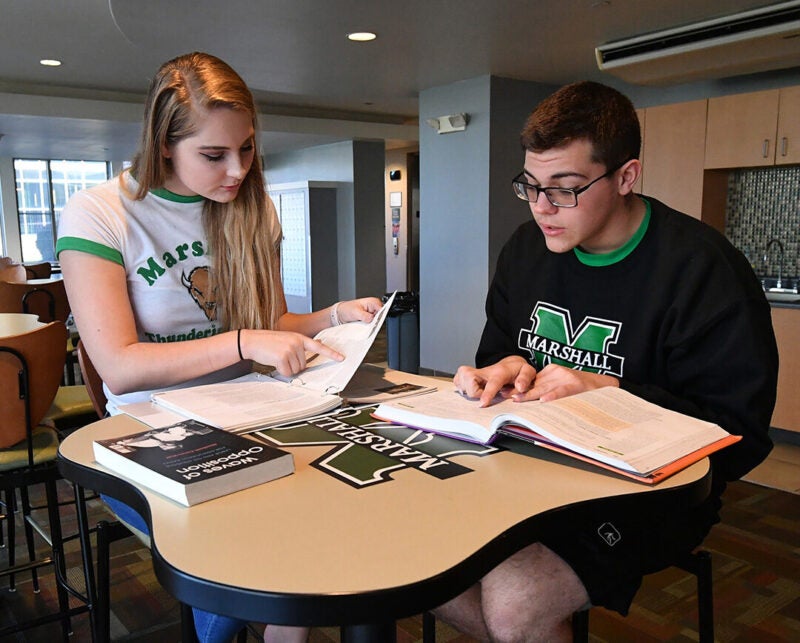 Students sit at a table studying together in the first year lounge