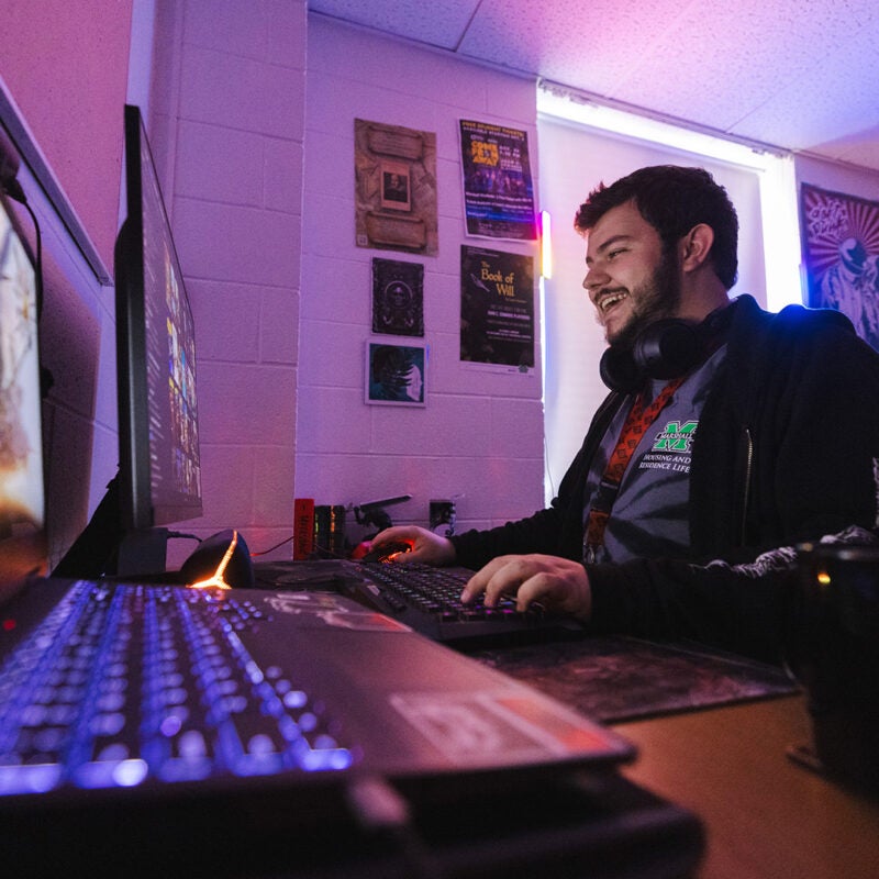 A student plays video games in a residence hall at Marshall University