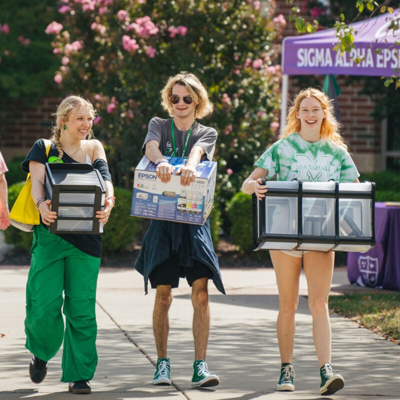 Students carry items while moving into their residence halls at Marshall University