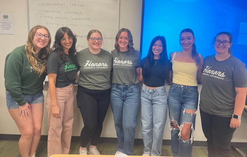students in the Honors College Themed Community smile together for a photo during an event