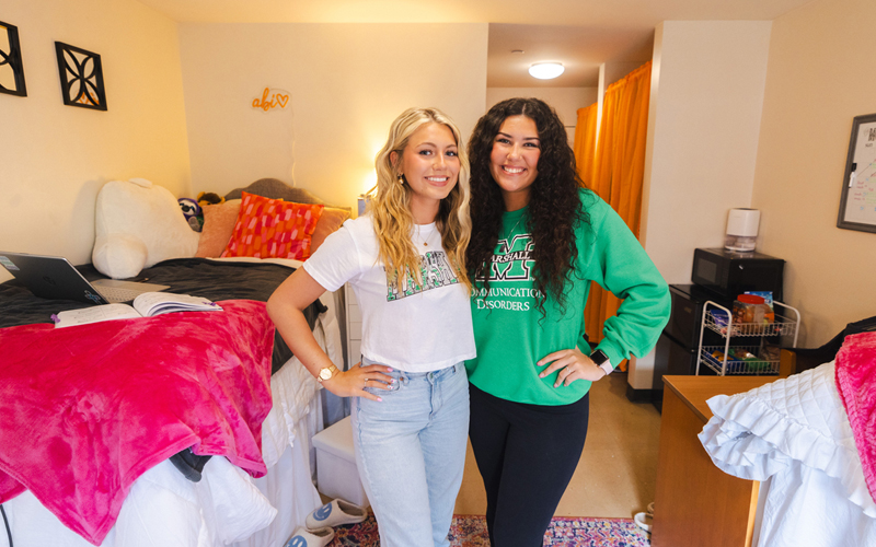 Students smile together in their residence hall rooms.