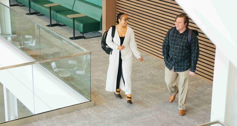 two students walking through the school of business