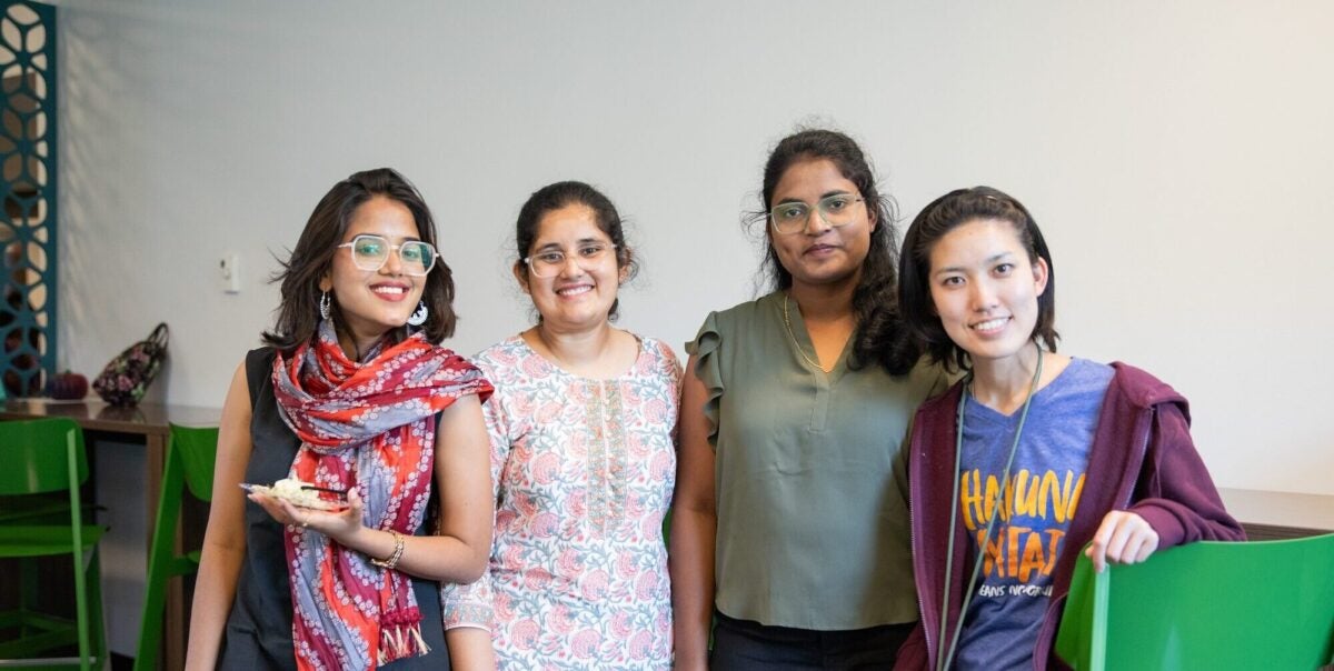 group of four students smiling at the camera