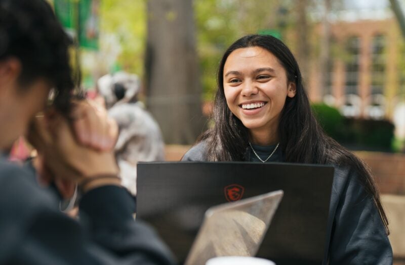 two students laughing on campus outside the Memorial Student Center