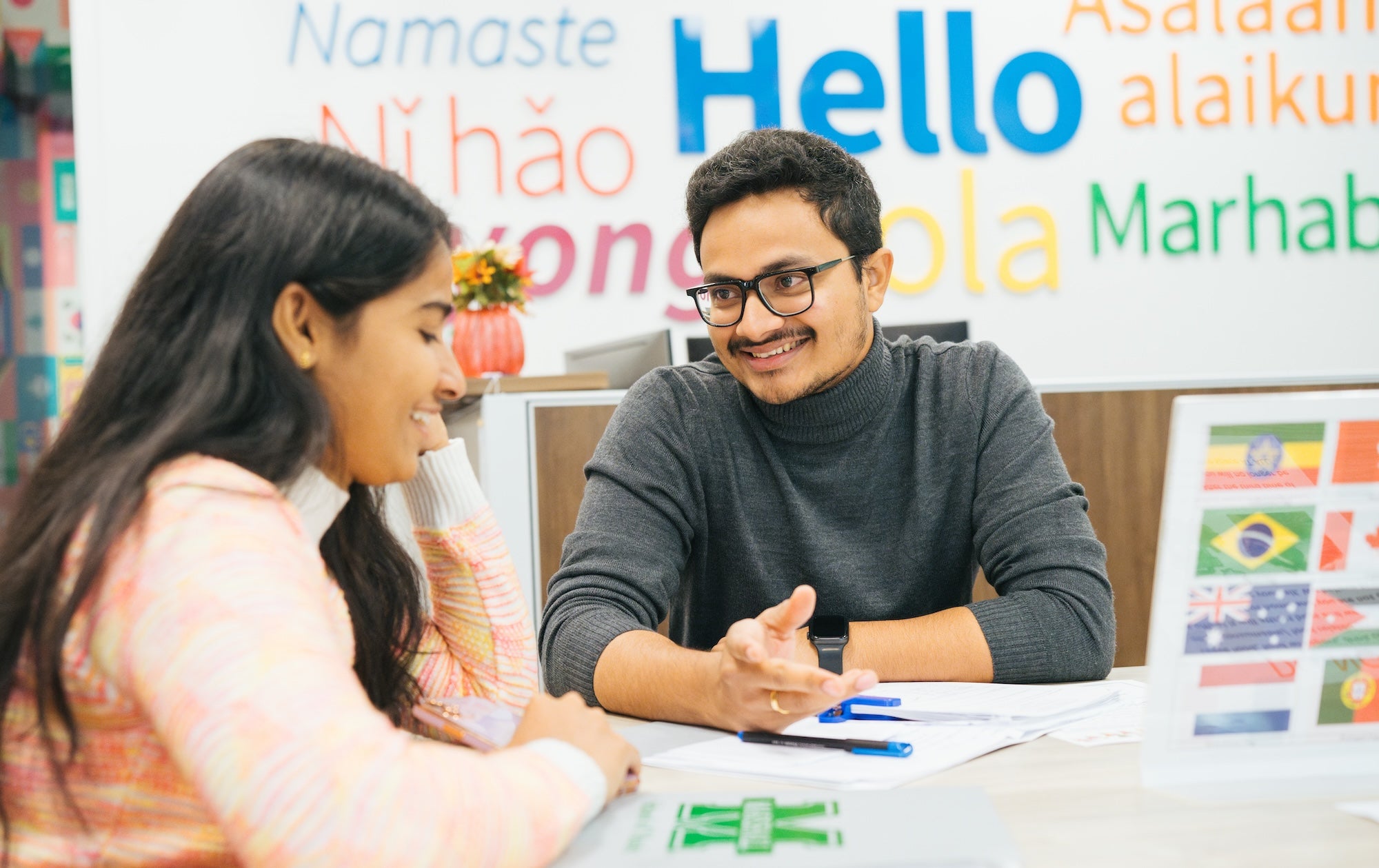 two students talking at a table