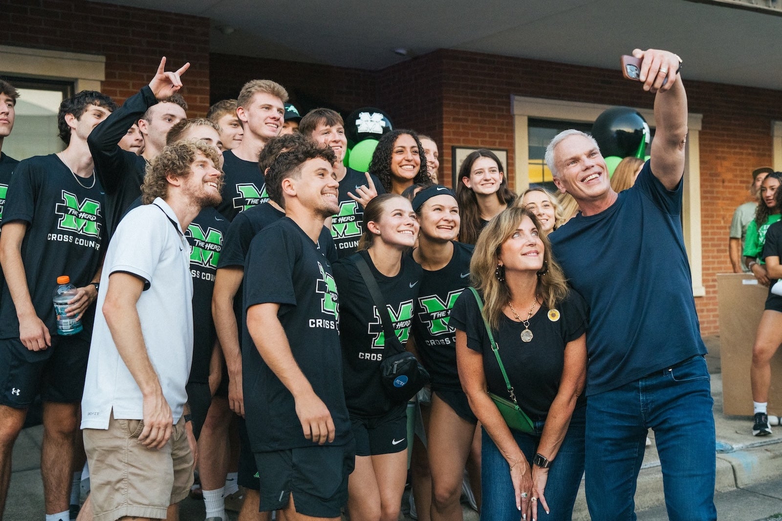 Cross Country team posing for a selfie with Brad and Alys Smith