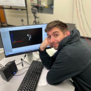 Dr Jared Steele at a computer with biomechanics info on the computer screens