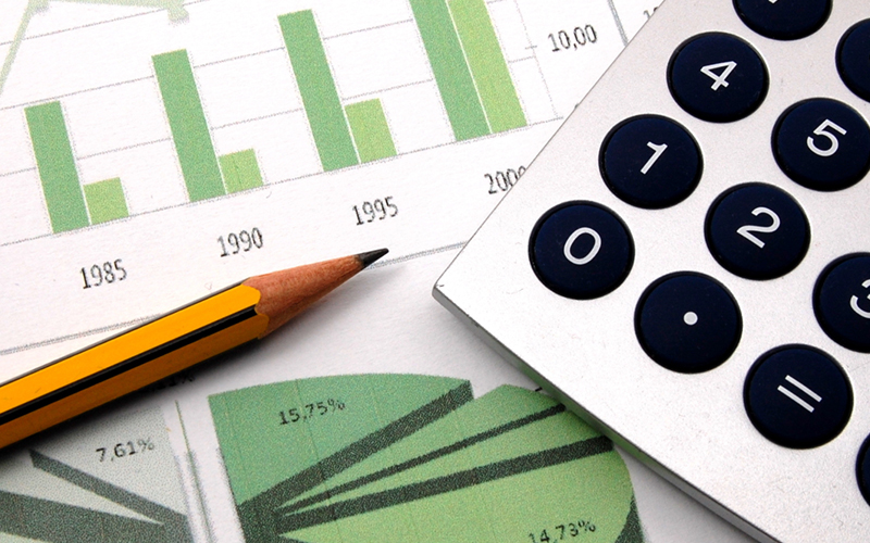 A paper of graphs with a pencil and calculator on top