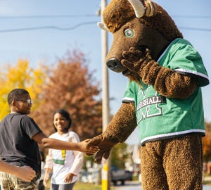 Marco shakes hands with young fans during an event.