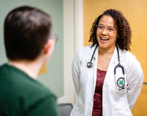 Taylor Pearson, Marshall University Joan C. Edwards School of Medicine, laughs with a patient during a consultation