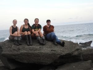 Students smile together on a beach during a summer field course in Costa Rica