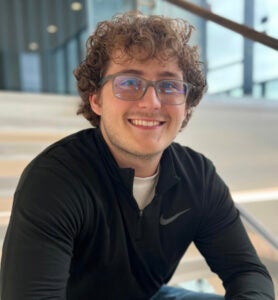 Luke Jeffery sits on the stairs in Marshall University's Brad D. Smith Center for Business & Innovation