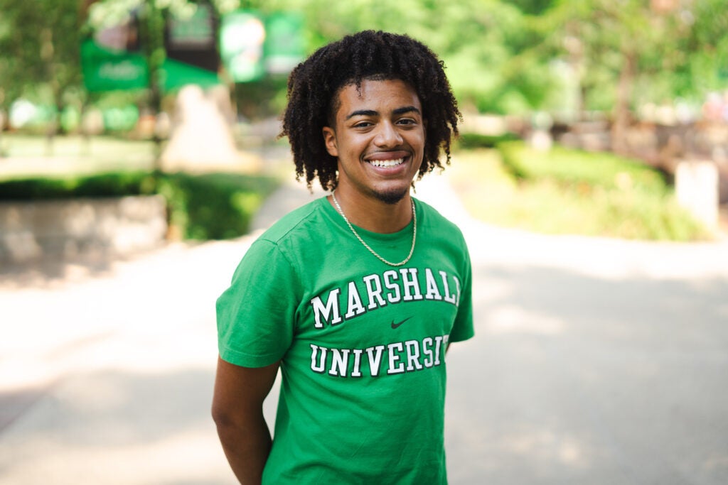 Tristan Hornbuckle smiles at the camera while standing on Marshall University's Huntington campus