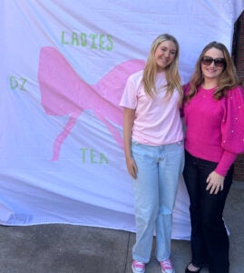 Sydney Barbour with her mother, Michelle Biggs in front of a sorority banner