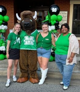 Kay Steele and her fellow interns post for a photo with Marshall University's mascot, Marco.