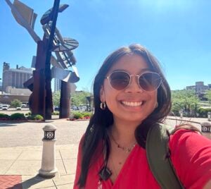 Gracie takes a selfie with the Clay Center statue behind her
